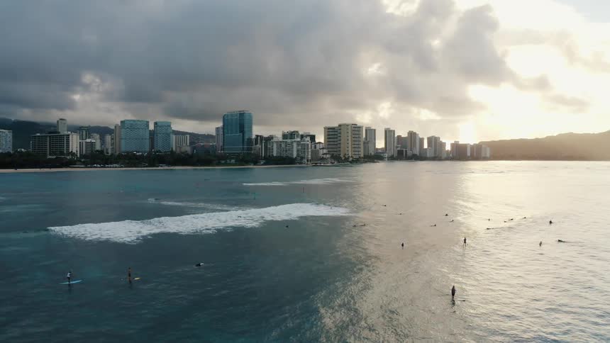 People playing in the tide off the coast of a metropolis