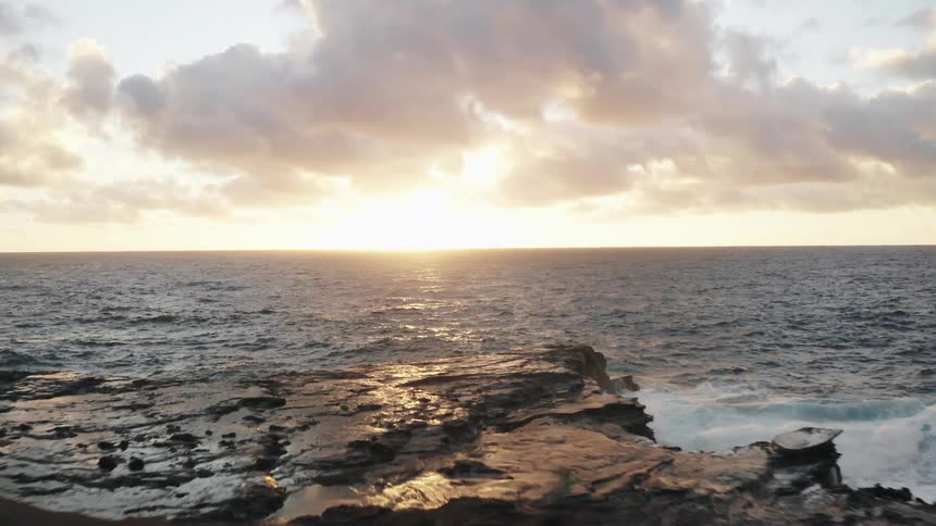 The sun sets on the horizon over an ocean