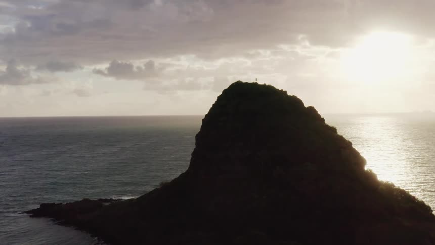 Sunshine briefly casts forest covered island into silhouette