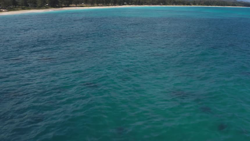 Blue green water on the coast near a mountain range