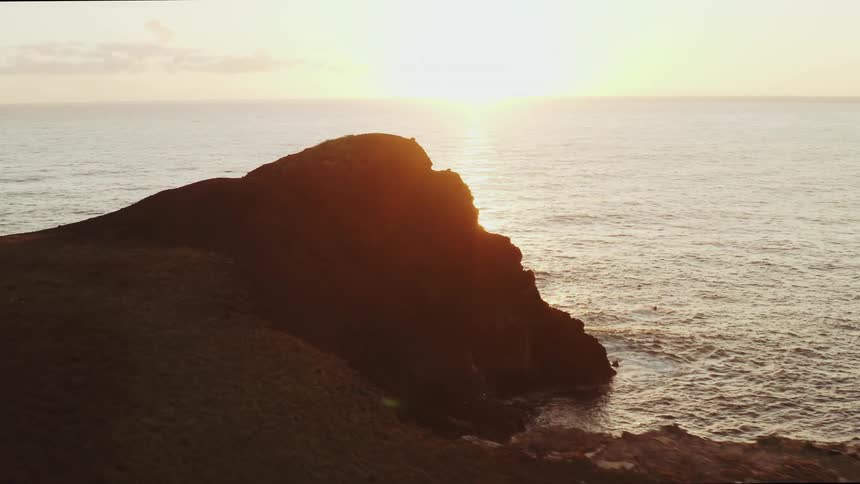 The sun is rising off the shore