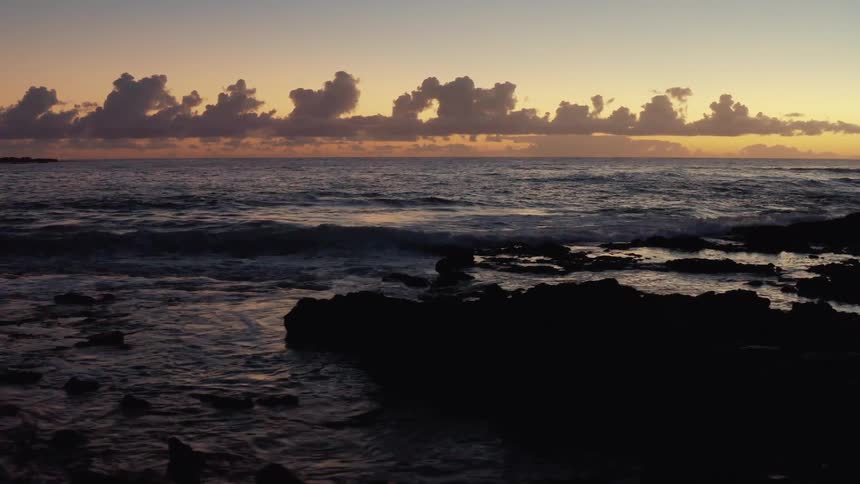 Tide rolling into a rocky beach at sunset