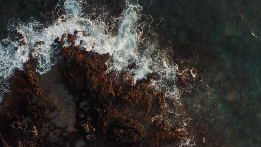 Birds eye view of waves crashing in to rocks