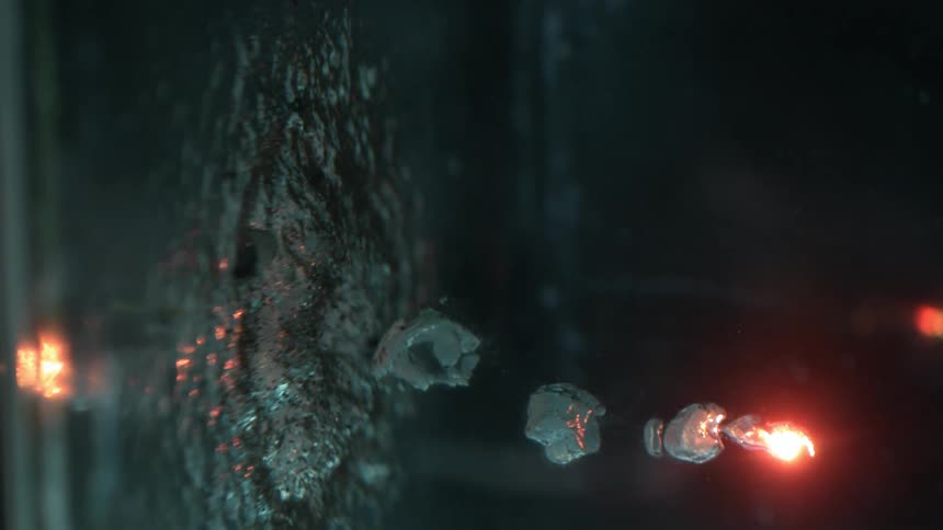 Incandescent particles sinking on clear water
