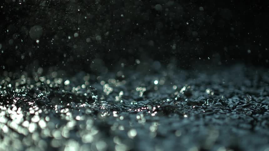 Drops of water falling into body of water in slow motion