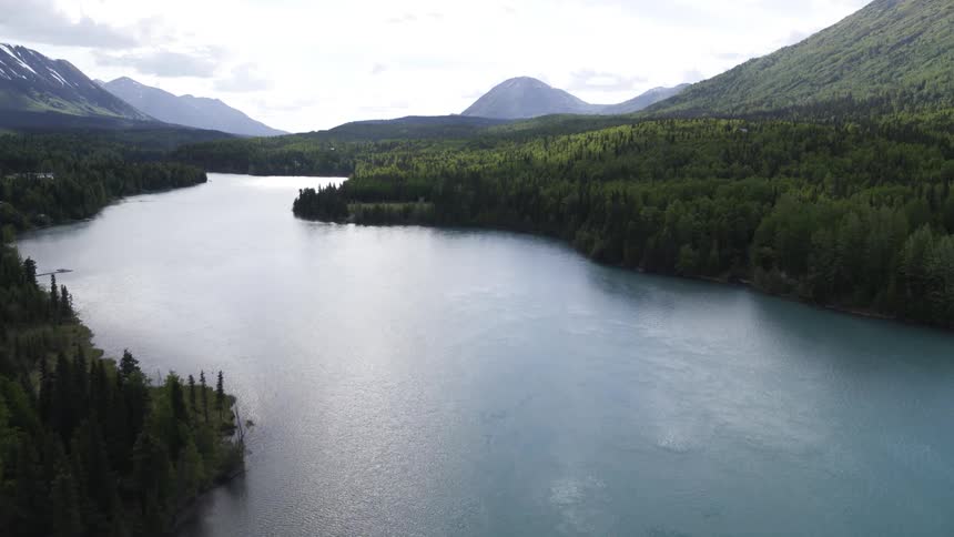 Aerial view of large river running through valley between mountains