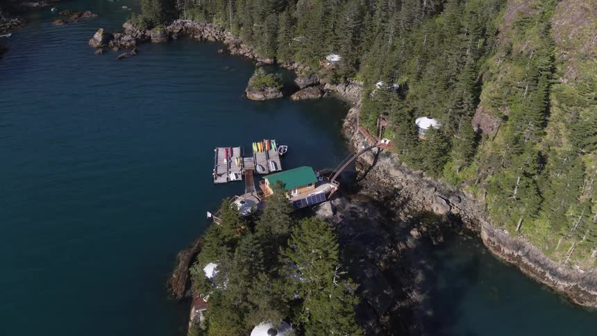 Aerial view of kayak lodge on lake surrounded by pine trees