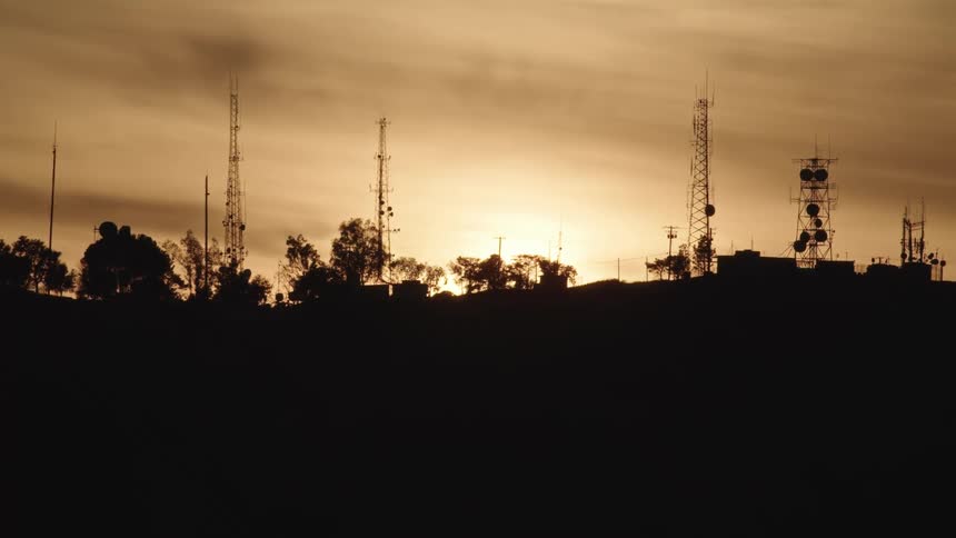 Time lapse of sunrise behind silhouetted communications towers