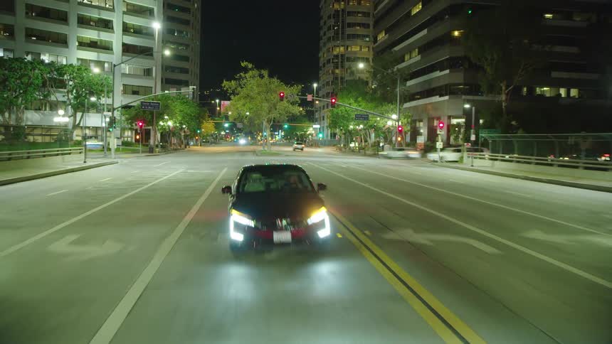 Time lapse of car driving through city at night