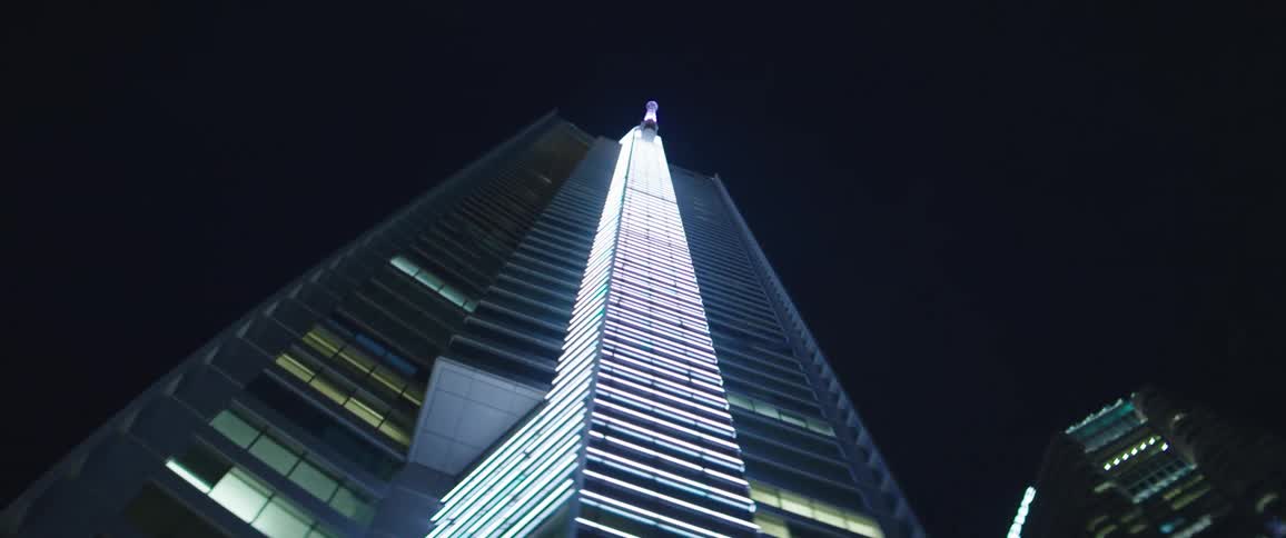 A glowing skyscraper in a metropolis at night