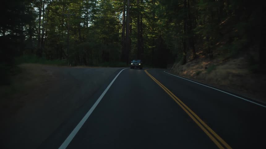 A car is driving on a road outdoors