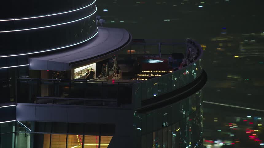 Aerial view of bar and lounge atop a hirise in city downtown at night