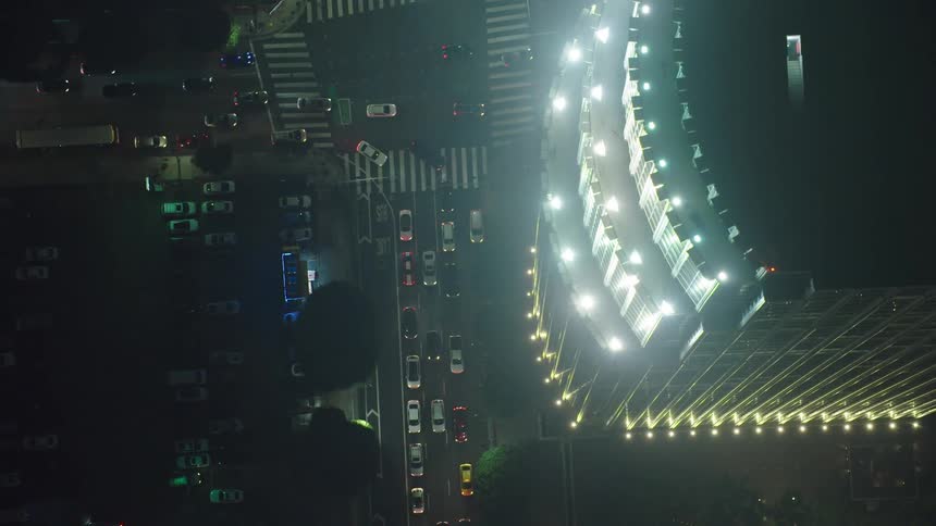 Skyscraper towers over busy city intersection at night