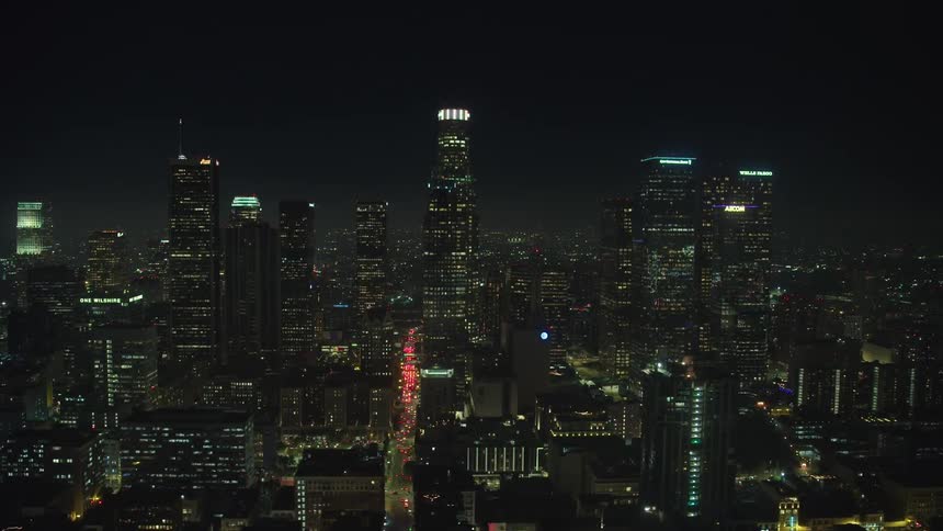 High rise buildings in a downtown city are lit up at night