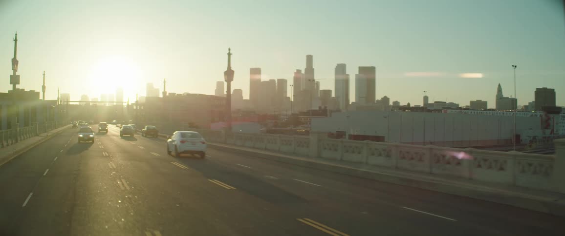 Cars are driving on a highway at sunset