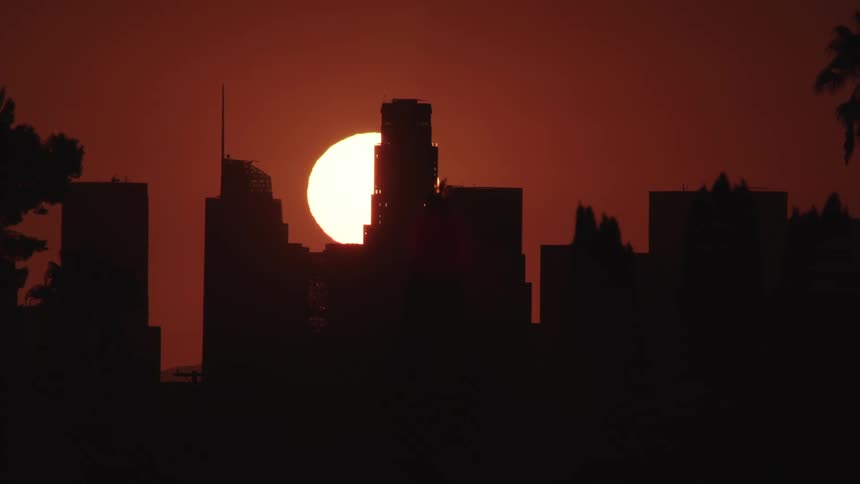 Red sun goes down behind the city
