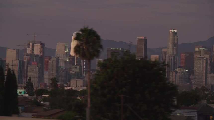 Skyline of a city with vehicles driving past