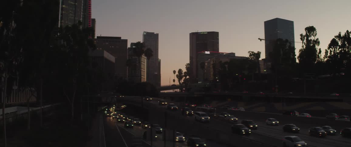 Cars drive on a busy highway through downtown