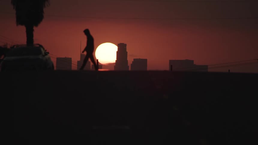 The sun sets behind the building