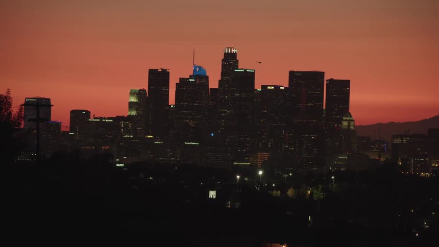 Aerial view of the illuminated tall buildings and skyscrapers at sunset