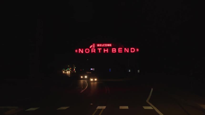Traveling on a highway under a red neon welcome to north bend sign