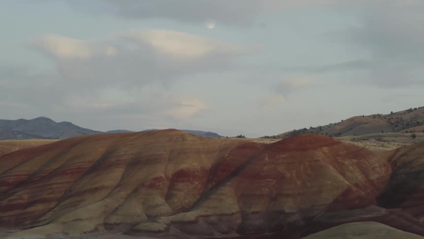 Full moon over painted hills at sunset