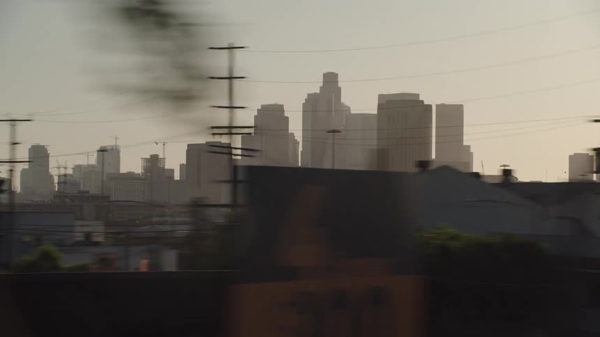The sun sets behind a city