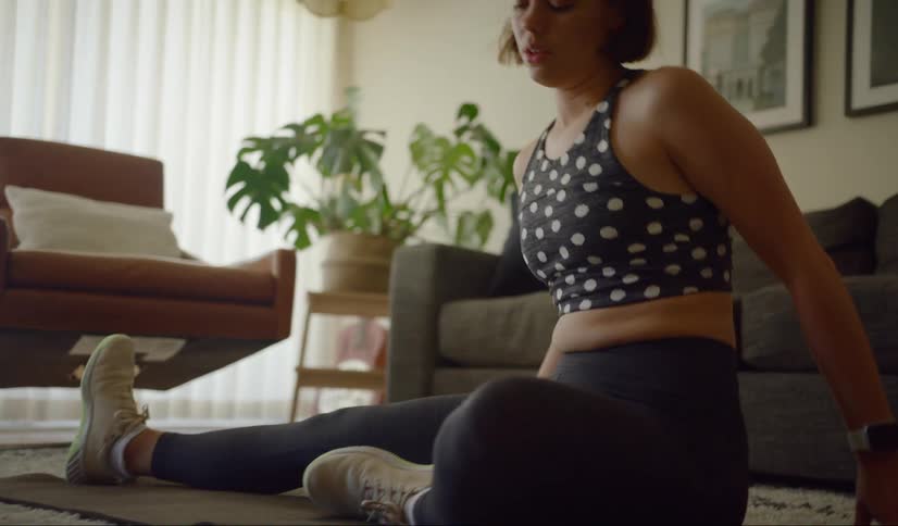 Woman stretches and works out in the living room at home