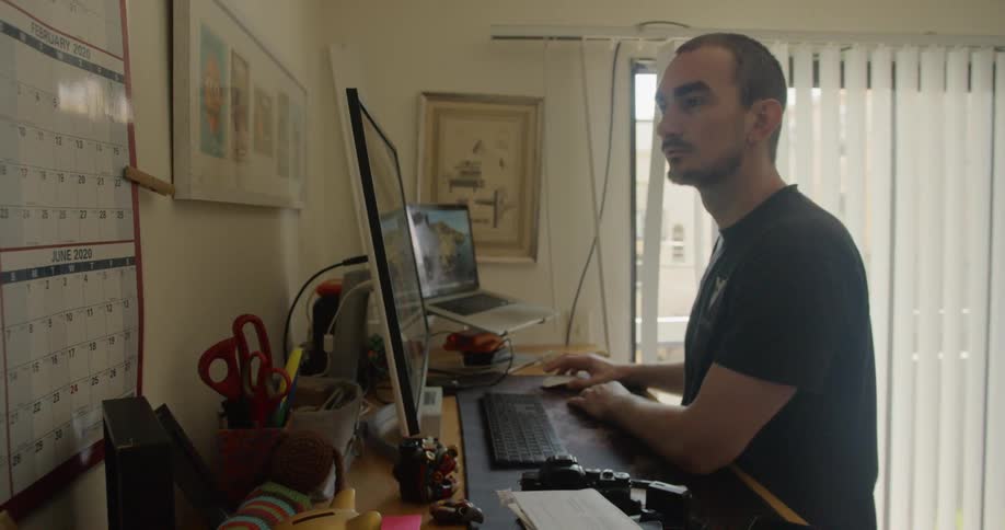 A man using a computer at a stand up desk