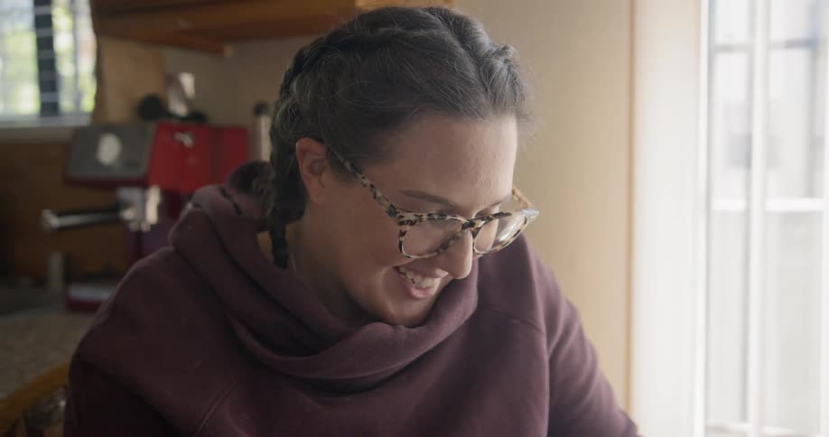 A woman sitting down smiling in the kitchen