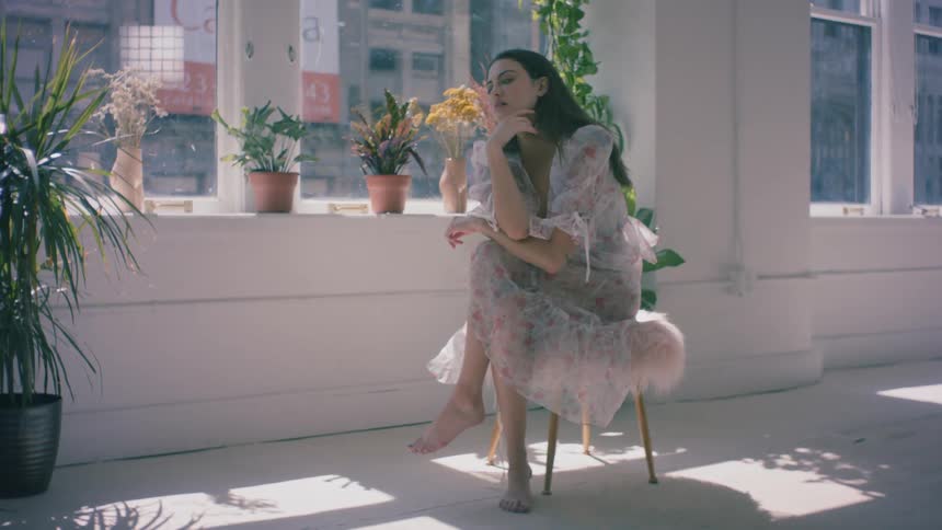 Female model sitting on stool posing for a photo shoot