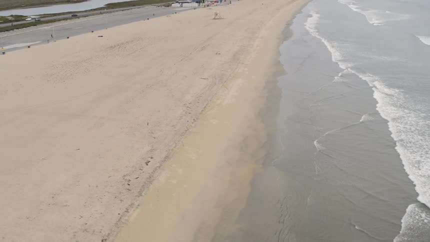 Empty beach near freeway at day