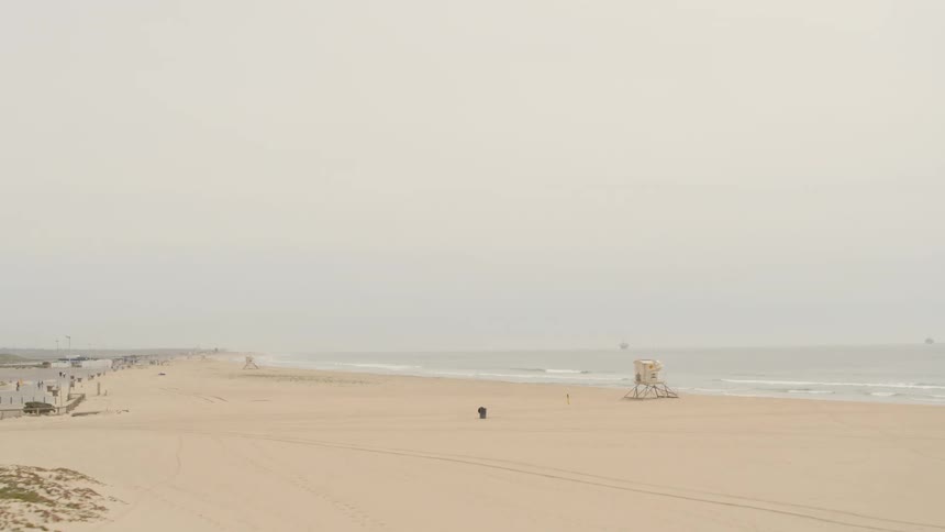 Ocean waves crash on an empty sandy beach