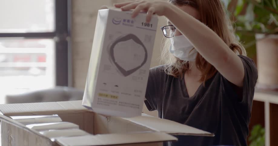A woman unpacks a box of medical supplies