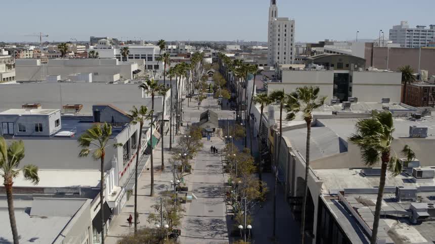 Pedestrians walk a city sidewalk with no vehicles in sight