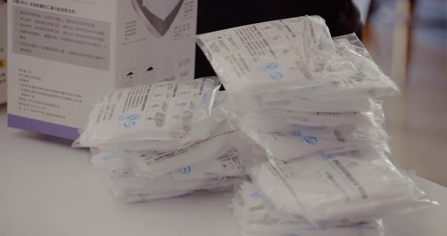 Nurse unpacking a box of face masks on table