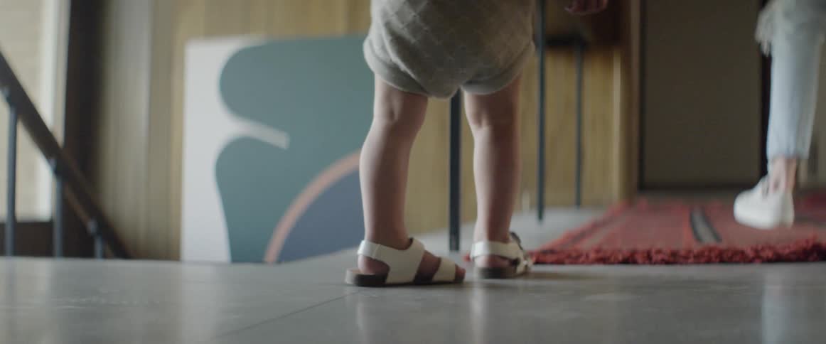 A child stands near the stairs