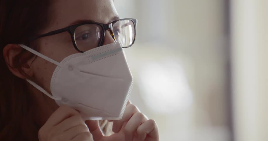 A young girls puts a mask on