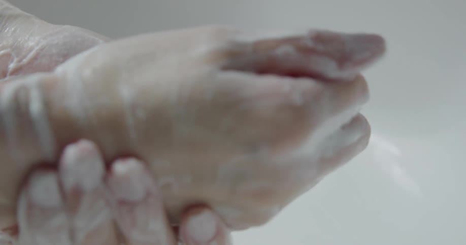 A person is rubbing soap all over their hands