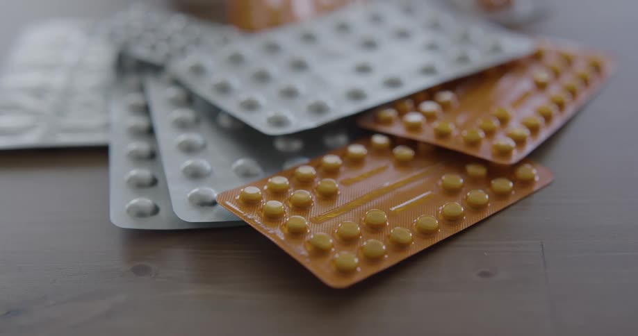 Gray and brown packages of pills laying on a table