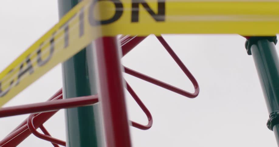 Kids playground on park closed with yellow caution tape