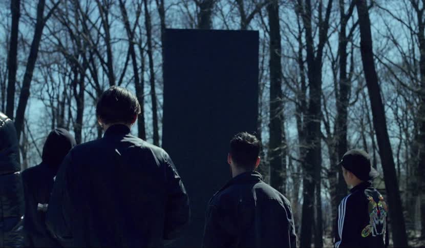Some people stand at the sculpture
