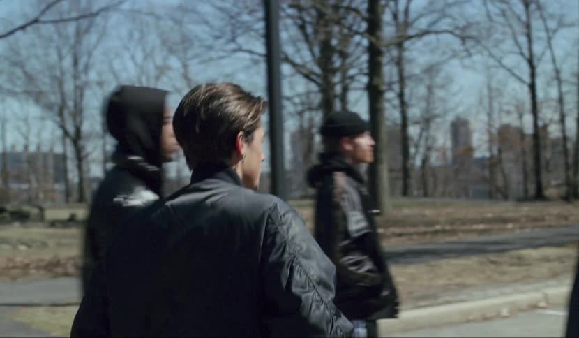 Man gets out of the the black car aggressively and walks into the group of young people in the woodland