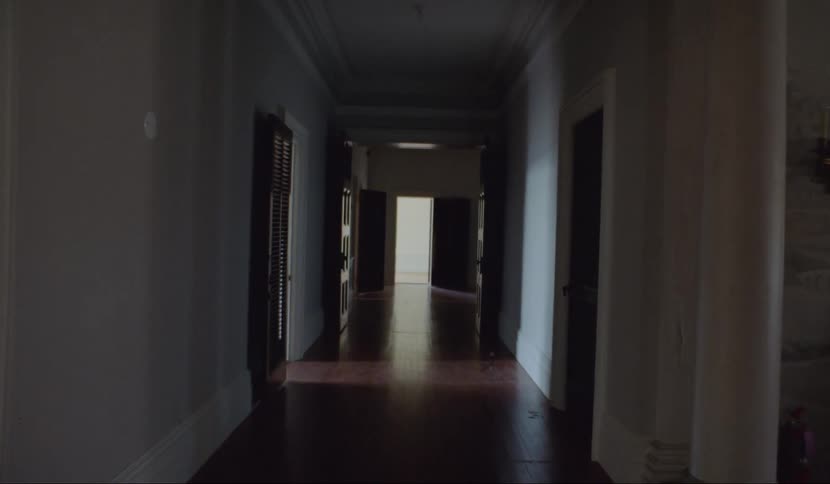 A corridor is cloaked in shadow
