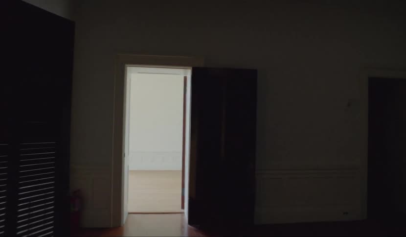 Light shines through open doors into a dark corridor