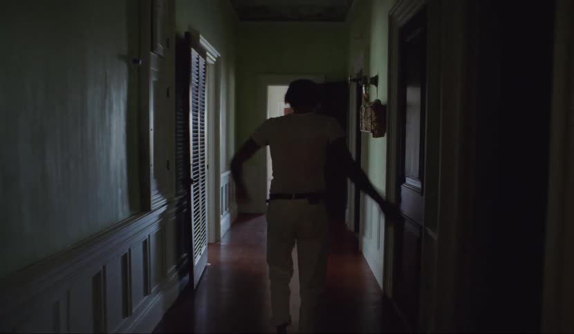 A man is collapsing while walking through a house