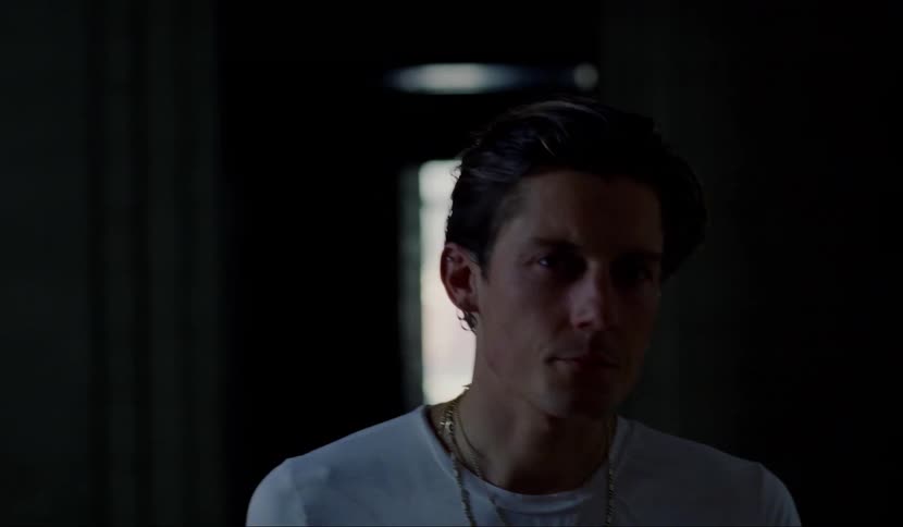 A man is walking through a dark hallway