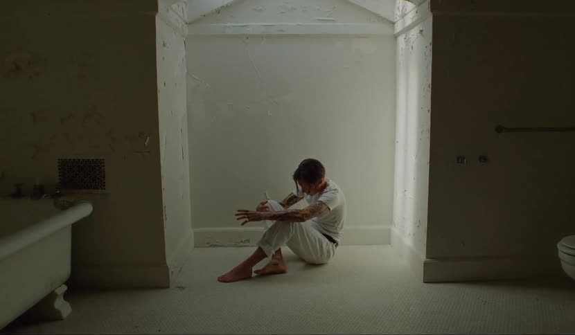 A man is walking through a house and looks powerless and sad