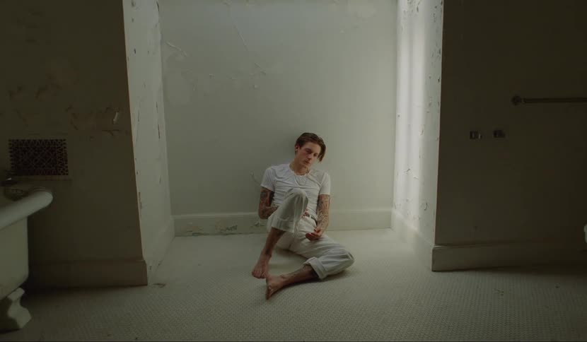 A teenager sits on the bathroom floor