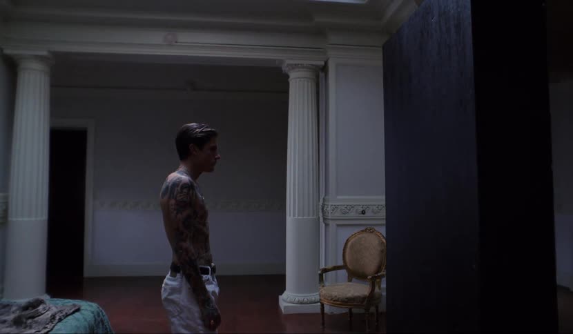 A man walks towards a large black box in the middle of a bedroom doorway